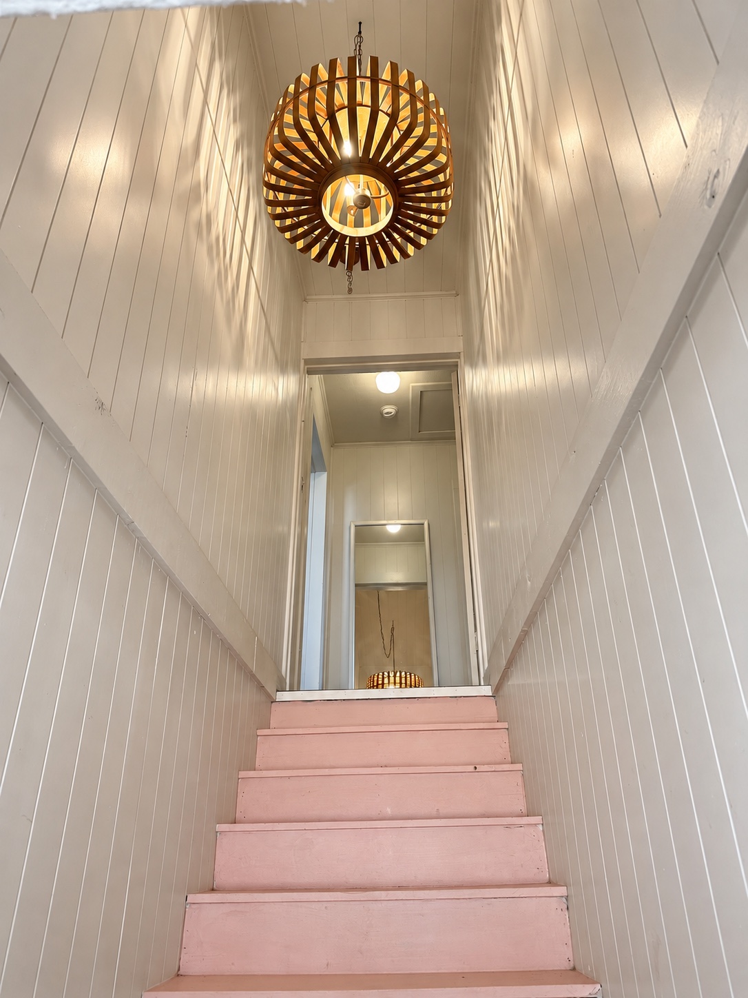 The Pink House's pink staircase and sculptural wooden pendant
